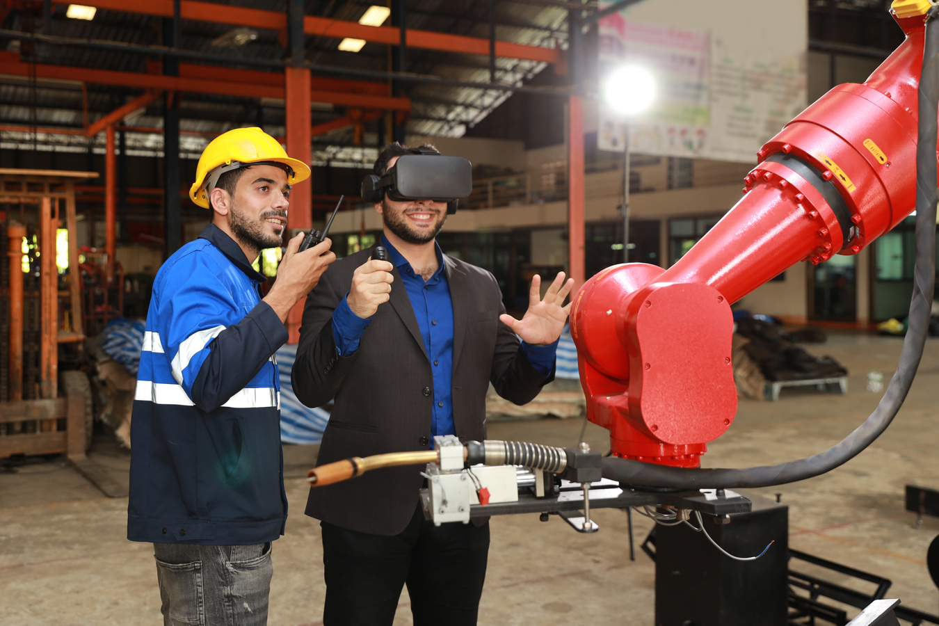 Professional heavy industry technician engineer with workwear and businessman maintenance and check part of robot arm machine with VR virtual in factory automotive. Industrial and technology concept